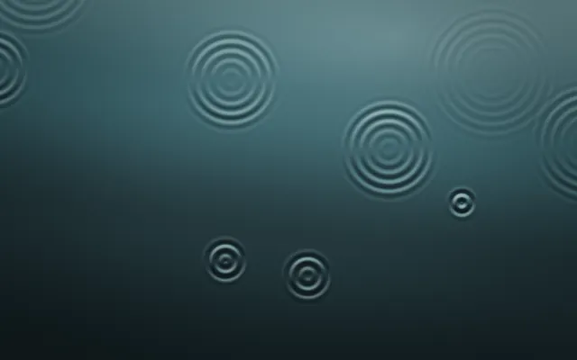 Concentric rings spread across dark teal water, some large and faint, others small and sharp.