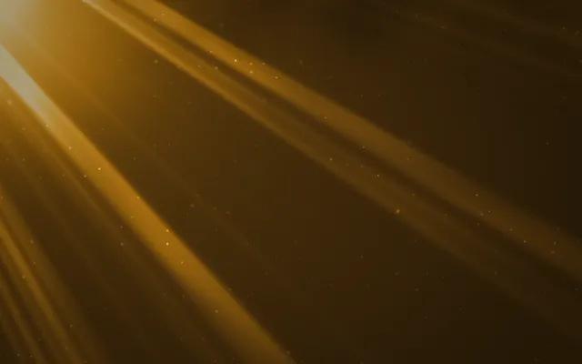 Golden shafts of sunlight stream diagonally from the upper left across a dark amber background, flecked with dust.